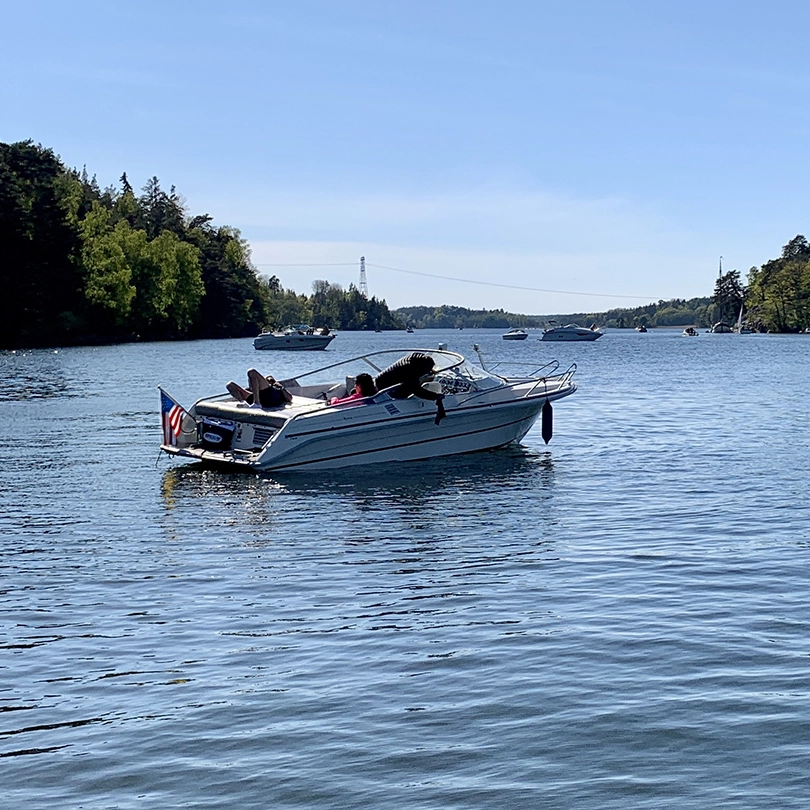 A personal sized boat floating on a lake.